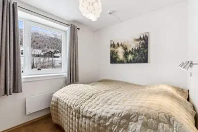 a bedroom with a bed and a window at Moderne og sentral leilighet på Geilo in Geilo