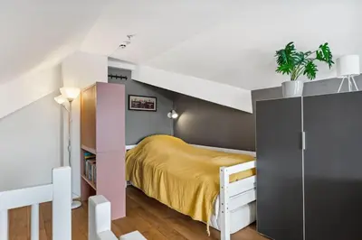 a small bedroom with a bed and a book shelf at Moderne og sentral leilighet på Geilo in Geilo