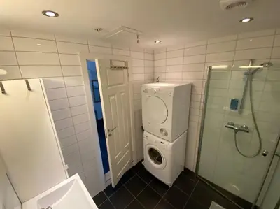 a bathroom with a washing machine and a shower at Moderne og sentral leilighet på Geilo in Geilo