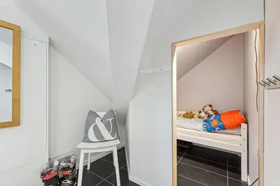 a small bedroom with a bunk bed with a mirror at Moderne og sentral leilighet på Geilo in Geilo