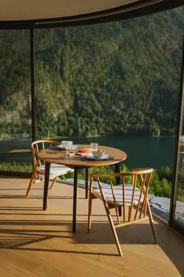 a wooden table and chairs on a deck with a view at Sogndal Fjordpanorama- The Panorama View in Kaupanger