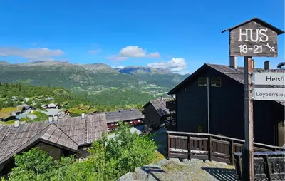 a sign in front of a black building with mountains at Awesome Apartment In Hemsedal With Wifi in Hemsedal