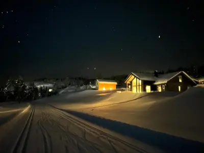 a house is covered in snow at night at Nydelig hytte ved Voss Ski og Tursenter in Giljane