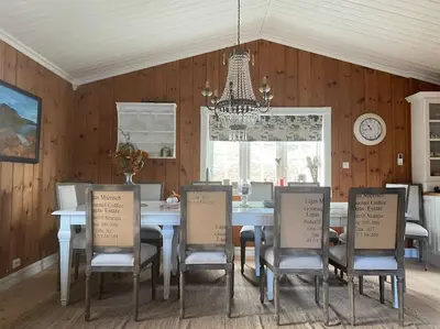 a dining room with a table and chairs and a clock at Heimro in Torvetjørn