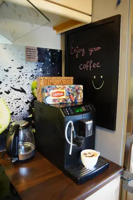 a coffee maker on a counter with a cup of coffee at Cozy room in a house with a garden on the island of Askøy, near Bergen in Askøy