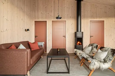 a living room with a couch and a fireplace at Halne Fjellstugu in Maurset