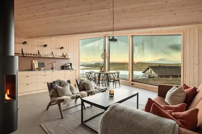 a living room with a fireplace and a table at Halne Fjellstugu in Maurset