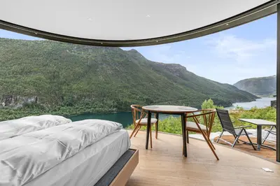a bedroom with a bed and a table and chairs at Sogndal Fjordpanorama- The Panorama View 2 in Sogndal