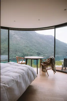 a bedroom with a bed and a table and chairs at Sogndal Fjordpanorama- The Panorama View 2 in Sogndal
