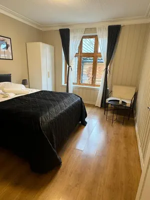 a bedroom with a bed and a table and a window at Central stay apartment - 303 in Bergen
