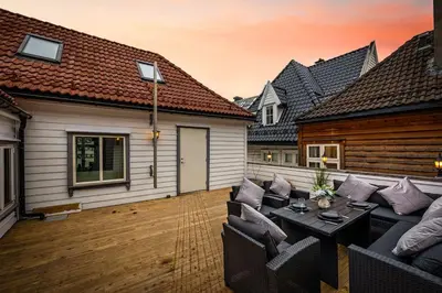 a patio with a couch and a table in front of a house at Central stay apartment - 303 in Bergen