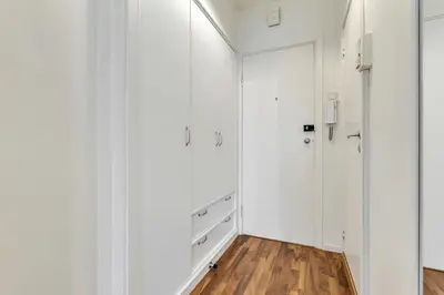 a white closet with white cabinets and a wooden floor at Cozy Studio Retreat in Bergen