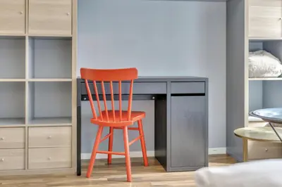a orange chair sitting in front of a desk at Cozy Studio Retreat in Bergen