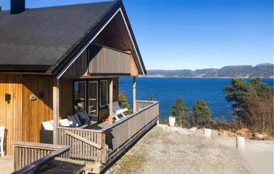 a house with a large deck with a view of the water at Stunning Home In Lensvik With Wifi in Lensvik