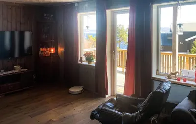 a living room with a couch and two large windows at Stunning Home In Lensvik With Wifi in Lensvik