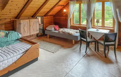 a bedroom with a bed and a table and chairs at 3 Bedroom Beautiful Home In Vik I Sogn in Stadheim