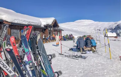 a group of people sitting outside of a ski lodge at 3 Bedroom Beautiful Home In Vik I Sogn in Stadheim