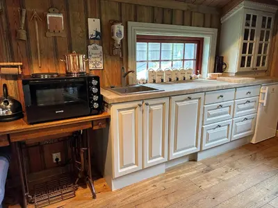 a kitchen with white cabinets and a microwave at Eventyrtunet in idyllic Tuddal in Hjartdal