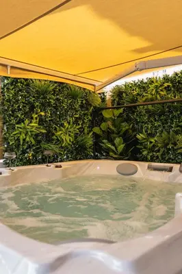 an outdoor jacuzzi tub with a yellow umbrella at Dinbnb Homes I Bergen's #1 BNB I Jacuzzi & Fireplace & Balcony in Bergen