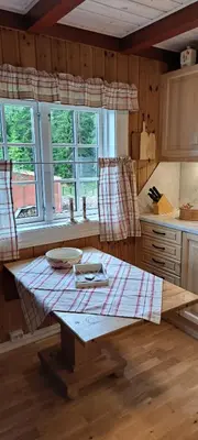 a kitchen with a wooden table in a room at Vesletun in Balestrand
