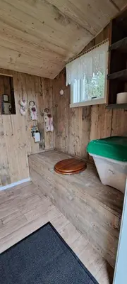 a wooden bathroom with a toilet and a bath tub at Vesletun in Balestrand