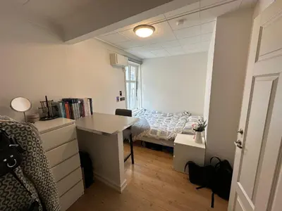 a bedroom with a bed and a desk in it at Sjarmerende bolig like ved togstasjonen in Bergen