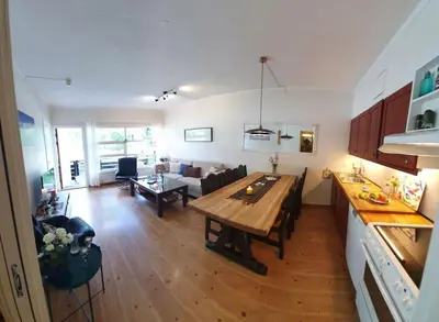 a kitchen and a living room with a wooden table at Fin leilighet i Geilo sentrum - kort vei til alt in Geilo