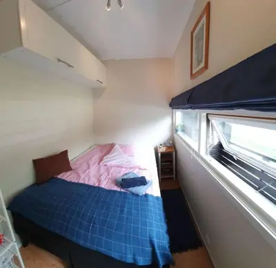 a bedroom with a blue bed and a window at Fin leilighet i Geilo sentrum - kort vei til alt in Geilo