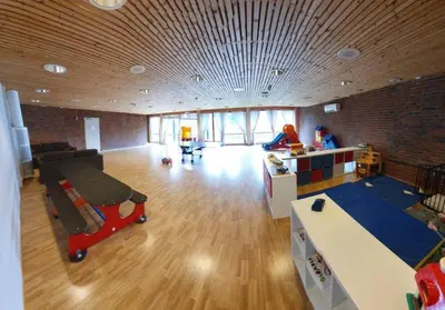 a large room with a playroom with a table and a room with at Fin leilighet i Geilo sentrum - kort vei til alt in Geilo
