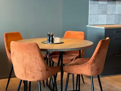 a wooden table with four chairs and a cup of coffee on it at Riddertunet Beitostølen in Beitostøl