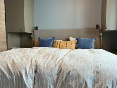 a bedroom with a large bed with blue pillows at Riddertunet Beitostølen in Beitostøl