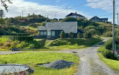 a house on a hill with a gravel road at 3 Bedroom Stunning Home In Bøvågen in Bøvågen