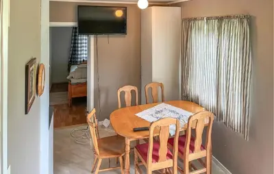 a dining room table with four chairs and a television at Gorgeous Apartment In Eresfjord in Nauste