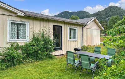 a table and chairs in front of a house at Gorgeous Apartment In Eresfjord in Nauste