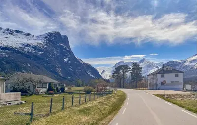 a road with a house and mountains in the background at Gorgeous Apartment In Eresfjord in Nauste