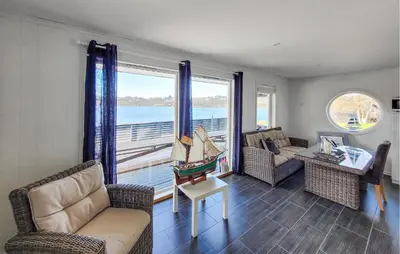 a living room with chairs and a large window at Stunning Home In Sveio With Kitchen in Sveio