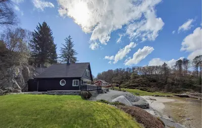 a house on a hill next to a river at Stunning Home In Sveio With Kitchen in Sveio