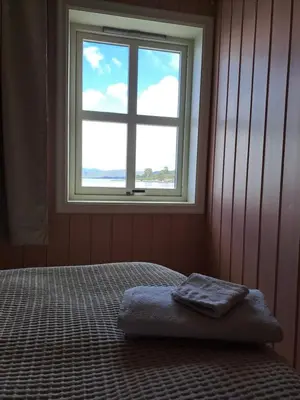 a bedroom with a bed in front of a window at Bay View Island Room - Svanøy in Svanøy