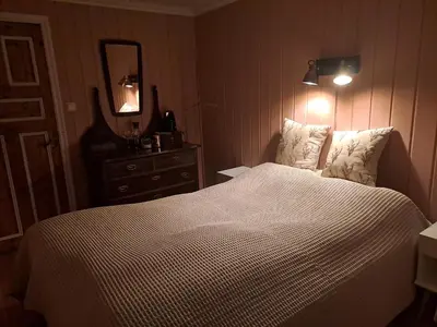 a bedroom with a bed and a dresser and a mirror at Bay View Island Room - Svanøy in Svanøy