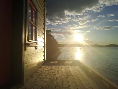 a window of a house with a view of the water at Bay View Island Room - Svanøy in Svanøy