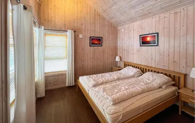 a bedroom with a bed in a wooden wall at Gorgeous Home In Venabygd With Sauna in Venabygd