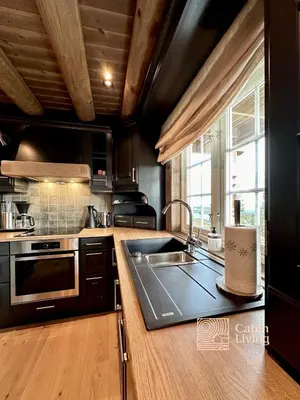 a kitchen with a sink and a stove at New log cabin with sauna, waxing shed & bench at Sjusjøen in Ringsaker