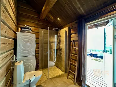 a bathroom with a shower and a toilet and a sink at New log cabin with sauna, waxing shed & bench at Sjusjøen in Ringsaker