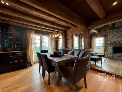 a dining room with a table and a couch at New log cabin with sauna, waxing shed & bench at Sjusjøen in Ringsaker