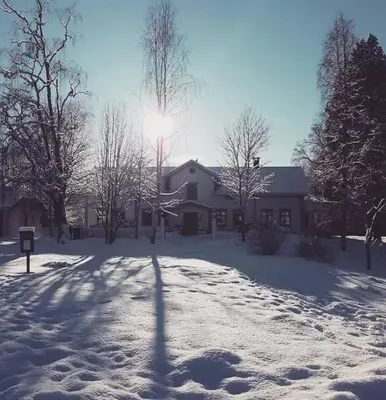 a house with the sun shining in the snow at Hurdal Gjestegård in Hurdal