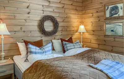 a bedroom with a bed in a log cabin at Awesome Home In Stryn in Stryn