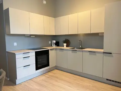 a kitchen with white cabinets and a sink at Høyegaarden in Bergen