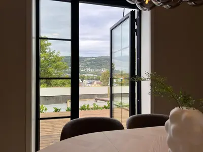 a dining room with a table and a large window at Høyegaarden in Bergen