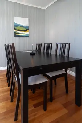 a dining room table with chairs and a candle on it at Sunny apartment in Ålesund city in Ålesund