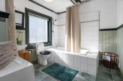a bathroom with a tub and a toilet and a sink at Sunny apartment in Ålesund city in Ålesund